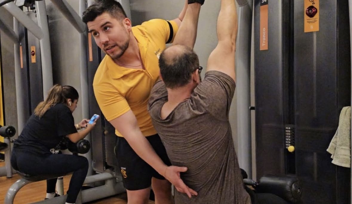Nicolás corrigiendo la técnica de un alumno en la máquina